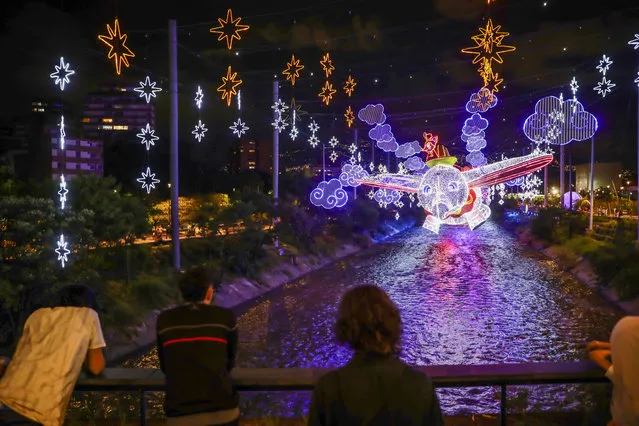People enjoy as Christmas lights display in Parques del Rio in the city of Medellin, Antioquia, Colombia on November 25, 2023. From November 30th to January 8th, 2024, between 6:00 p.m. and 12:00 a.m., the 16 districts and five townships of Medellin will be illuminated by the Christmas Lights, featuring nine million LED bulbs, 650 kilometers of luminous tubing, and 27,000 handcrafted figures. In celebration of Disney's centenary, 14 of its iconic stories and characters will take center stage along the river corridor. (Photo by Juancho Torres/Anadolu via Getty Images)