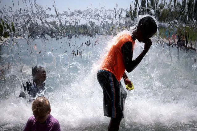 Children play and cool off in a waterfall at the Yards Park as temperatures reached 97 degrees fahrenheit on August 12, 2021 in Washington, DC. A recently released climate report from the United Nations predicts that the world will continue to warm with devastating heat waves, floods and fires becoming more frequent. (Photo by Win McNamee/Getty Images)