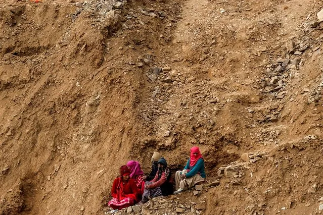 Women watch the rescue operations at a tunnel, where workers are trapped after the tunnel collapsed, from a hillside in Uttarkashi in the northern state of Uttarakhand, India on November 28, 2023. (Photo by Francis Mascarenhas/Reuters)