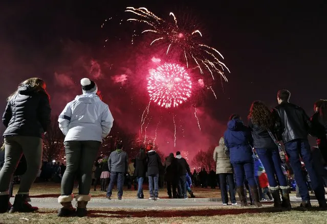 Fireworks explode over Boston Common during New Year's Eve celebrations in Boston, Tuesday, December 31, 2013. (Photo by Michael Dwyer/AP Photo)