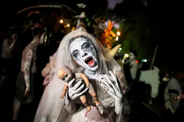 A reveller dressed as “La Llorona” participates in a parade known as “La Calabiuza” on the eve of the Day of the Dead in Tonacatepeque, El Salvador on November 1, 2022. (Photo by Jose Cabezas/Reuters)