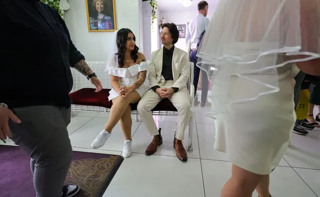 Shirley Rodriguez (L) and Chris Gennuso of California wait in the lobby with other couples for their wedding ceremony at the Little White Wedding Chapel on December 31, 2023 in Las Vegas, Nevada. In what could be a record-breaking date for weddings in the city, thousands of couples are expected to get married on the specialty date with the repeating 1-2-3 1-2-3 pattern that also coincides with the New Year's Eve holiday and a weekend. The most popular date for Las Vegas weddings was in 2007, when 4,492 couples exchanged vows on July 7, or 7/7/07. Since 1953, more than five million weddings have been held in the city, when the Daily Herald in London published an article referring to Las Vegas as the “Wedding Capital of the World”. (Photo by Ethan Miller/Getty Images)