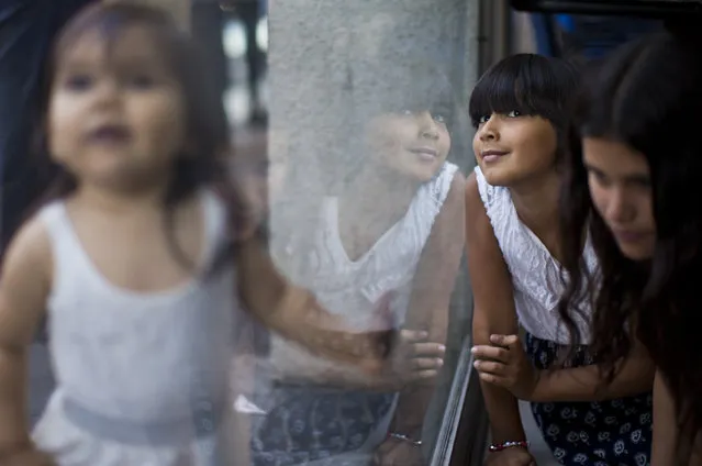 In this December 15, 2018 photo, Emma, a transgender student of the Amaranta Gomez school plays with her sisters while she waits to update her identity card at the national registry of persons, in Santiago, Chile. After suffering years of discrimination some 20 transgender minors aged 6 to 17 have recently found hope at Latin America's first school for trans children. (Photo by Esteban Felix/AP Photo)