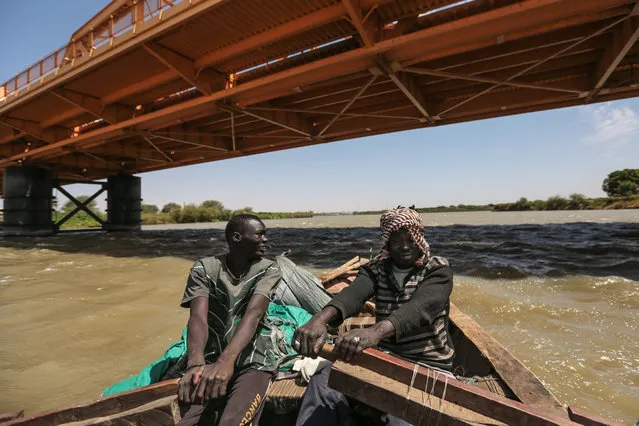 In this Wednesday, April 15, 2015 photo, Sudanese fishermen row their boat beneath Omdurman Bridge on the Nile River, in Khartoum, Sudan. (Photo by Mosa'ab Elshamy/AP Photo)