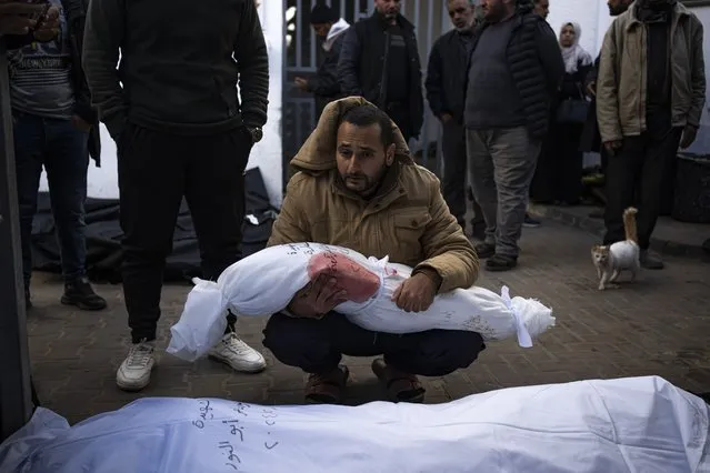 A man holds the body of his daughter who was killed in the Israeli bombardment of the Gaza Strip, at a hospital morgue in Rafah, Wednesday, February 21, 2024. (Photo by Fatima Shbair/AP Photo)