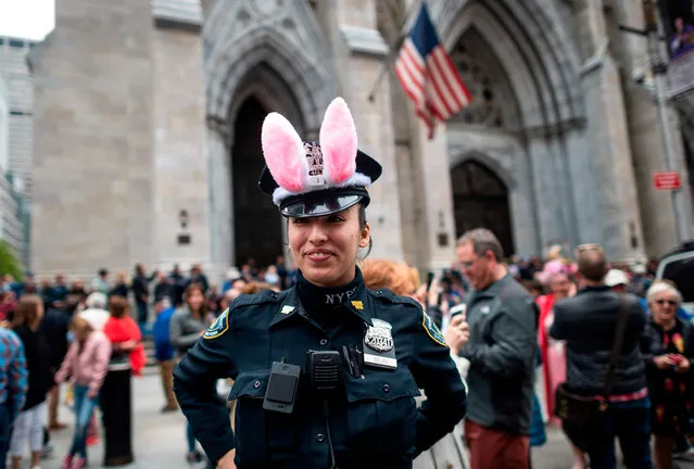 A policewoman wears bunny ears during the annual NYC Easter Parade and Bonnet Festival on 5th Avenue in Manhattan on April 21, 2019 in New York City. (Photo by Johannes Eisele/AFP Photo)