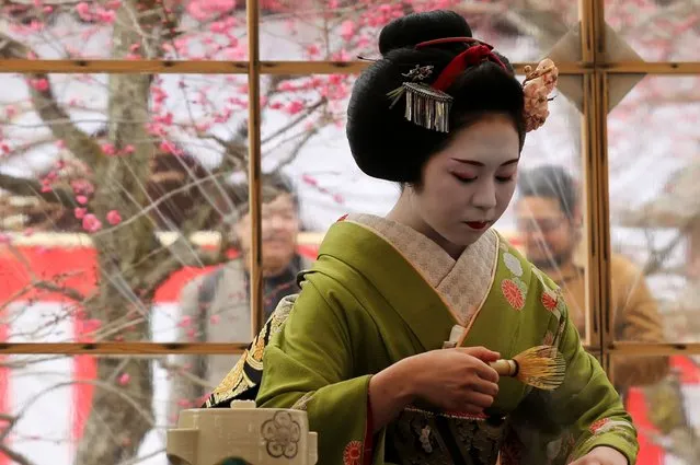 Japanese Geisha prepares green tea as Miko looks during the annual Baikasai, Plum Blossom Festival at Kitano Tenmangu Shrine on February 25, 2014 in Kyoto, Japan. This annual event commemorates enshrined Michizane Sugawara, a politician and plum-blossom aficionado of the Heian-Period, who died in the year 903. (Photo by Buddhika Weerasinghe/Getty Images)