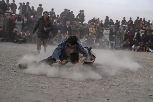 Afghan men wrestle in front of spectators in Kabul, Afghanistan, Friday, December 3 , 2021. The scene is one played out each week after Friday prayers in the sprawling Chaman-e-Huzori park in downtown Kabul, where men, mainly from Afghanistan's northern provinces, gather to watch and to compete in pahlawani, a traditional form of wrestling. (Photo by Petros Giannakouris/AP Photo)