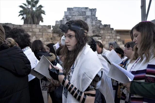 A member of Women of the Wall, wearing Tefillin, a cubic black leather box with leather straps, takes part in the Rosh Hodesh prayer marking the new month, at the Western Wall, the holiest site where Jews can pray, in the Old City of Jerusalem, Monday, January 23, 2023. The group has waged a decades-long campaign for gender equality at the holy site. (Photo by Maya Alleruzzo/AP Photo)