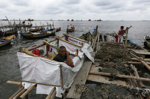A man is seen in temporary toilets over the sea at Cilincing slum area in North Jakarta, Indonesia, March 30, 2016. (Photo by Reuters/Beawiharta)