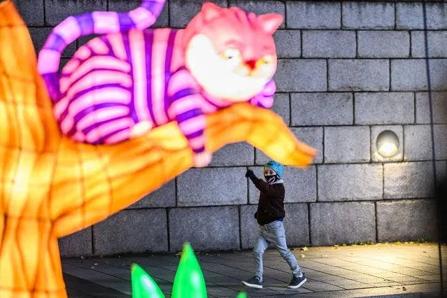 A child gestures as he visits the 13th Seoul Lantern Festival in the Cheonggyecheon area of Seoul on November 26, 2021. (Photo by Anthony Wallace/AFP Photo)
