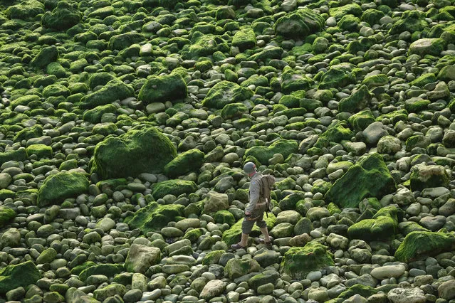 A U.S. Army Ranger dressed in the uniform of a U.S. Army Ranger from World War II walks along rocks below La Pointe du Hoc prior to scaling the nearby cliffs with colleagues in a re-enactment of the D-Day assault on June 05, 2019 near Cricqueville-en-Bessin, France. On June 6, 1944 U.S. Army Rangers scaled the cliffs under darkness to attack a fortified German position as part of the Allied D-Day invasion. Veterans, families, visitors and military personnel are gathering in Normandy to commemorate the June 6, 75th anniversary of D-Day, which heralded the Allied advance towards Germany and victory about 11 months later. (Photo by Sean Gallup/Getty Images)