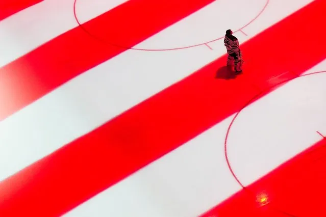 Dallas Stars goaltender Jake Oettinger stands in a projection of the American flag during the national anthem before an NHL hockey game against the Seattle Kraken, Saturday, March 30, 2024, in Seattle. (Photo by Lindsey Wasson/AP Photo)