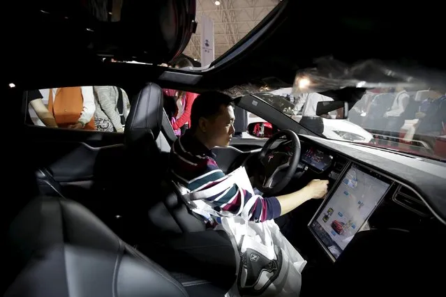 A visitor checks a Tesla Model S car during the Auto China 2016 in Beijing, China, April 25, 2016. (Photo by Jason Lee/Reuters)