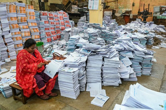 A woman works at a government's textbook printing press ahead of the reopening of schools after summer vacation in Hyderabad on May 29, 2024. (Photo by Noah Seelam/AFP Photo)