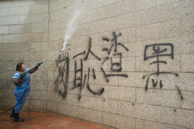 The employee of a cleaning company tries to remove a graffiti (“scum of society”) from the facade of the police station in the district Wan Chai with a water jet 19 August 2019 in Hong Kong China. In the former British crown colony of Hong Kong, protests against the influence of Beijing have entered a new round. The democracy movement has called for another major demonstration. (Photo by Gregor Fischer/dpa/Picture Alliance via Getty Images)
