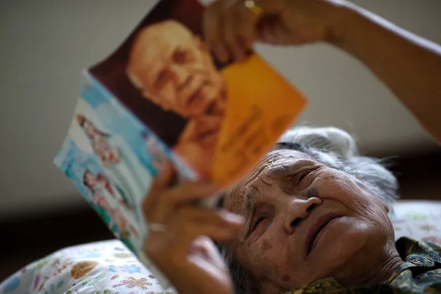 An elderly woman reads a Dhamma book during a physical therapy session at Bangkhae Home Foundation in Bangkok, Thailand, April 27, 2016. (Photo by Athit Perawongmetha/Reuters)