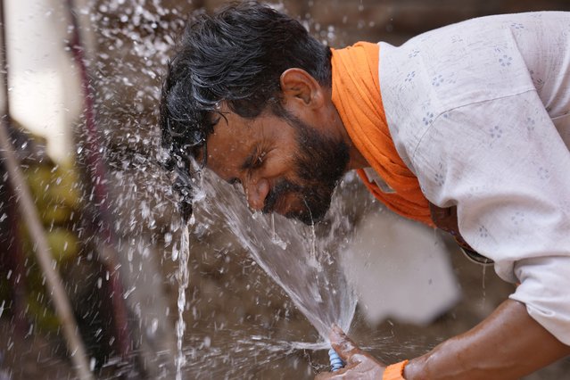 A man splashes water from a roadside tap on his face to cool off on a hot summer day in Lucknow, India, Monday, May 27, 2024. (Photo by Rajesh Kumar Singh/AP Photo)