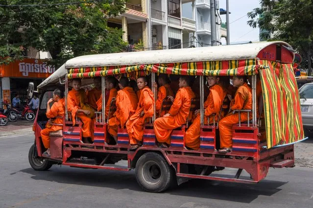 Buddhist monks ride in a tuk-tuk in Phnom Penh, Cambodia on September 11, 2019. (Photo by Tang Chhin Sothy/AFP Photo)