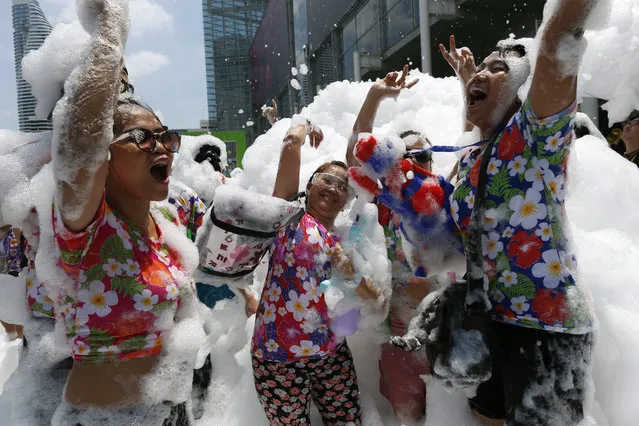 Revelers dance amid foam during a foam party held as part of the annual Songkran celebration in Bangkok, Thailand, 14 April 2017. The Songkran festival, the Thai traditional New Year, is held annually on 13 April. Songkran is also known as the water festival, and is celebrated with splashing water and putting powder on each others faces as a symbolic sign of cleansing and washing away the sins from the old year. (Photo by Rungroj Yongrit/EPA)