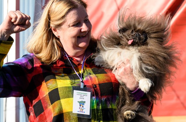 Owner Ann Lewis holds up her dog Wild Thang after winning first prize in the annual World's Ugliest Dog contest at the Sonoma-Marin Fair in Petaluma, California, on June 21, 2024. Wild Thang, a Pekingese dog who had already entered the competition four times, finally won the 34th annual World's Ugliest Dog competition and was awarded $5,000. (Photo by Josh Edelson/AFP Photo)