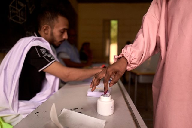 A voter dips his finger in an ink pot after casting his ballot at a polling station in Nouakchott on June 29, 2024. Mauritanians go to the polls Saturday to decide whether to re-elect President Mohamed Ould Cheikh El Ghazouani as head of the vast desert state, seen as a rock of relative stability in the volatile Sahel. Around 1.9 million registered voters are set to choose between seven candidates vying to lead the West African nation, which has largely withstood the tide of jihadism in the region and is set to become a gas producer. (Photo by Michele Cattani/AFP Photo)