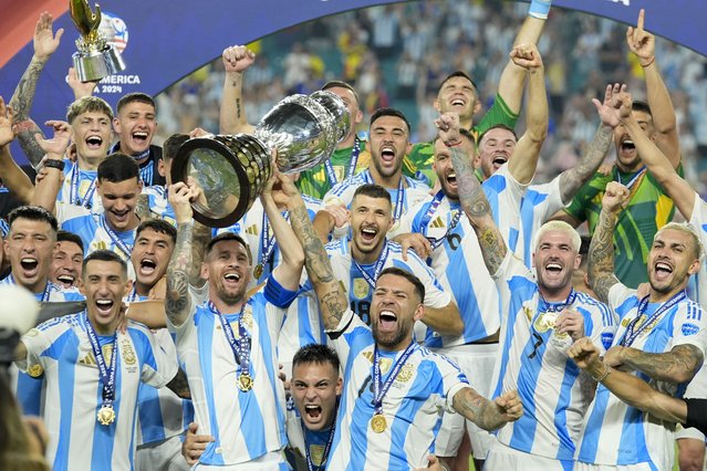 Argentina's Lionel Messi holds the trophy as celebrating with teammates after defeating Colombia in the Copa America final soccer match in Miami Gardens, Fla., Monday, July 15, 2024. (Photo by Rebecca Blackwell/AP Photo)