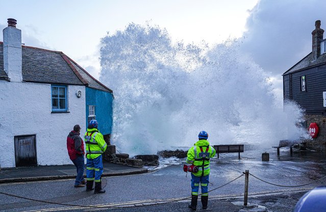 HM Coastguard personnel look on as waves crash over the harbour wall onto the street on April 09, 2024 in St Ives, Cornwall, England. On Monday, the Met Office issued severe weather warnings for wind across the southern and western coasts of England and Wales, effective until Tuesday afternoon. This follows the turbulent weather over the weekend, when Storm Kathleen, combined with high tides, generated massive waves along the Cornish coast. (Photo by Hugh Hastings/Getty Images)