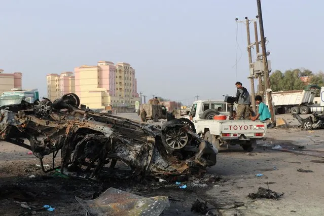 Soldiers look at the wreckage of a vehicle at a scene of a car bomb attack that killed a senior Yemeni military leader, Brigadier General Thabet Gawas, in the southern port city of Aden, Yemen on March 24, 2022. (Photo by Fawaz Salman/Reuters)