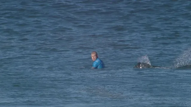 In this screen shot taken from video made available by the World Surf League, Australian surfer Mick Flanning is pursued by a shark, in Jeffrey's Bay, South Africa,  Sunday, July 19, 2015. Knocked off his board by an attacking shark, a surfer punched the creature during the televised finals of a world surfing competition in South Africa before escaping. Fanning was attacked by a shark on Sunday during the JBay Open but escaped without injuries. (Photo by World Surf League via AP Photo)