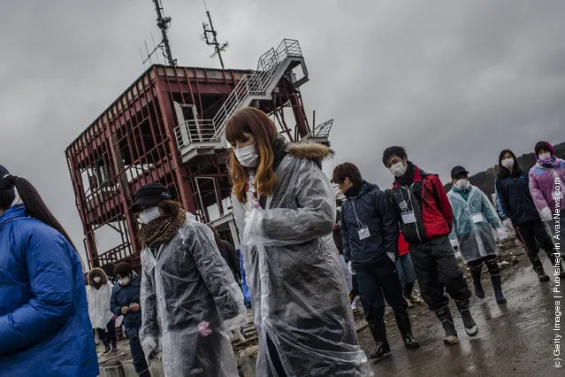 Students, volunteering to help clean the Shizukawa river from Kanto region, gather to their pay respects to tsunami victims at the site of the Minamisanriku Disaster Emergency Center headquarters now seen as a symbol of the tsunami, destroyed during last year's tsunami on March 11, 2012 near Ishinomaki
