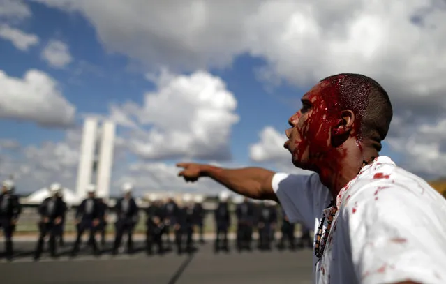 A demonstrator reacts after injuring his head during a protest against President Michel Temer and the latest corruption scandal to hit the country, in Brasilia, Brazil, May 24, 2017. (Photo by Ueslei Marcelino/Reuters)
