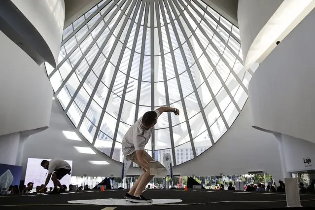 A young man throws a paper plane at the  Museum of Tomorrow during the World Paper Plane Championship, in Rio de Janeiro, Brazil, 18 April 2022. A total of eight competitors participated, four for the longest distance modality and another equal number for the duration time in the air. The champions will meet in Austria next May, when they will face rivals from 61 countries around the world whom they hope to overcome with their skills in the sixth edition of the World Paper Plane Championship. (Photo by Antonio Lacerda/EPA/EFE)