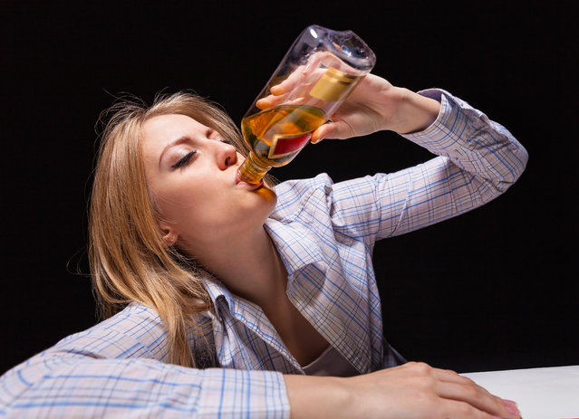 Young beautiful woman in depression, drinking alcohol. (Photo by Alamy Stock Photo)