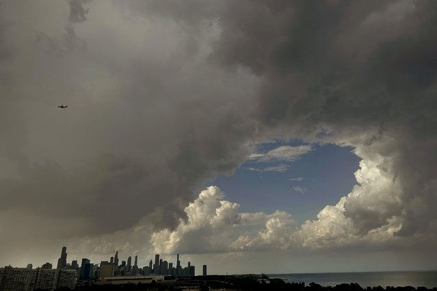 The sky opens up as one set of rain clouds head out over Lake Michigan and another approaches the Chicago skyline while a commercial airplane make the final approach to Midway International Airport, Friday, August 16, 2024, just days before the start of the Democratic National Convention in Chicago. (Photo by Charles Rex Arbogast/AP Photo)