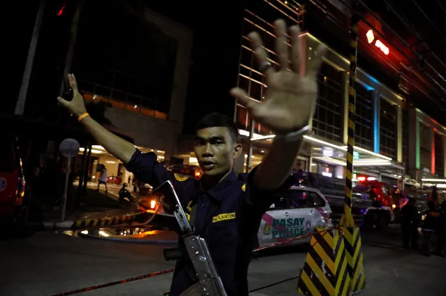 A security guard stops photographers from entering the vicinity of Resorts World Manila after gunshots and explosions were heard in Pasay City, Metro Manila, Philippines June 2, 2017. (Photo by Erik De Castro/Reuters)