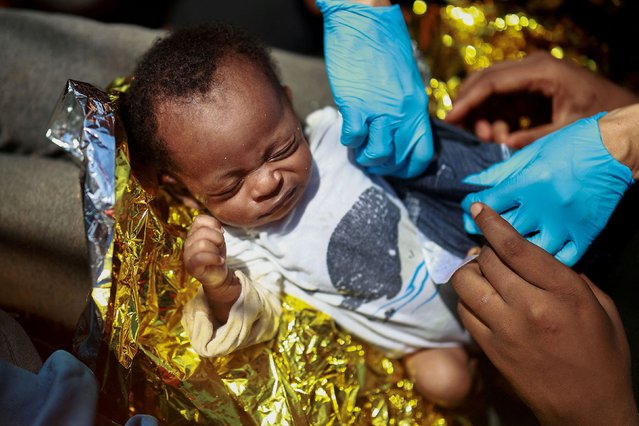 A young migrant is cared for by Dr. Isabel Zamarron on board the Open Arms rescue boat Astral in the central Mediterranean Sea on Saturday, August 10, 2024. (Photo by Juan Medina/Reuters)