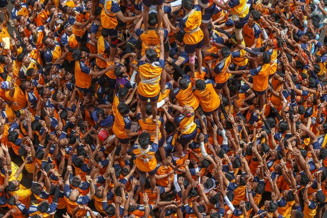 Indian devotees form a human pyramid to reach and break a “dahi-handi” (curd-pot), on the occasion of the Janmashtami Festival in Mumbai, India, 27 August 2024. Hindu devotees take part in the celebration, in which an earthen pot is suspended high above the ground and young men and children form a human pyramid to reach the pot and break it. The festival celebrates the birth of the Hindu god Lord Krishna, one of the most popular gods in Hinduism. (Photo by Divyakant Solanki/EPA/EFE)