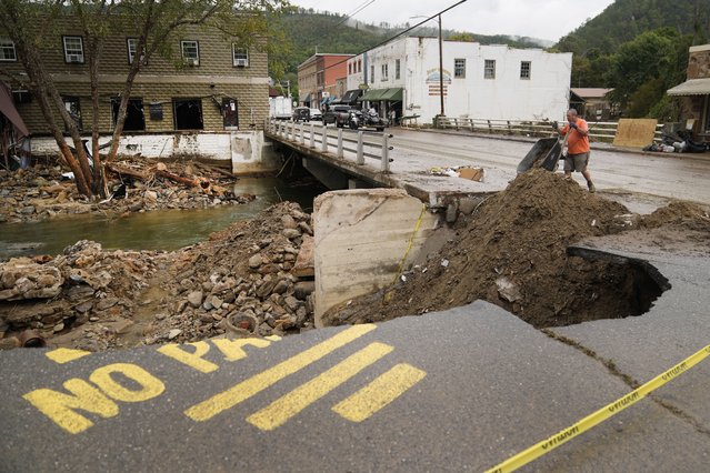 Len Frisbee dumps a wheelbarrow of dirt as he helps with clean up in the aftermath of Hurricane Helene Tuesday, October 1, 2024, in Hot Springs, N.C. (Photo by Jeff Roberson/AP Photo)