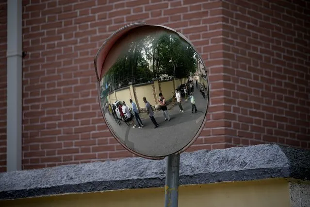 Residents are reflected on a mirror as they line up for nucleic acid tests on a street at a residential area, after the lockdown placed to curb the coronavirus disease (COVID-19) outbreak was lifted in Shanghai, China on June 7, 2022. (Photo by Aly Song/Reuters)