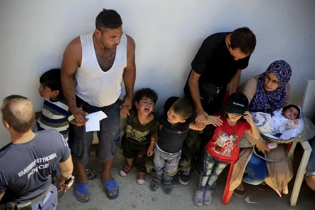 A child cries as Syrian refugees wait in line during a registration procedure at the national stadium of the Greek island of Kos, August 12, 2015. (Photo by Alkis Konstantinidis/Reuters)