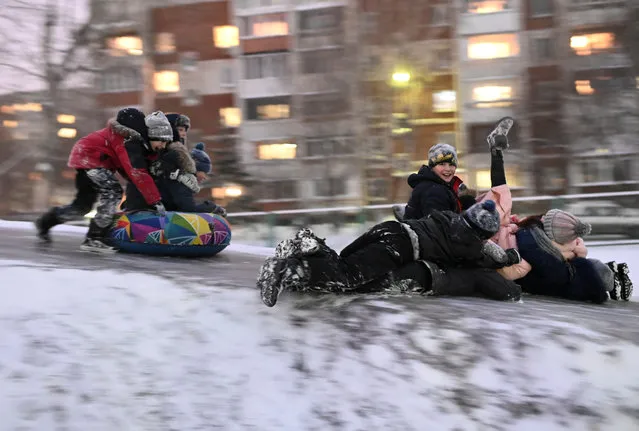Children slide down an ice-covered slope in Omsk, Russia on December 25, 2019. (Photo by Alexey Malgavko/Reuters)