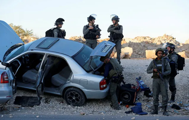 Israeli forces gather near a suspicious Palestinian car near Qalandiya checkpoint, near the West Bank city of Ramallah on August 3, 2017. (Photo by Ammar Awad/Reuters)