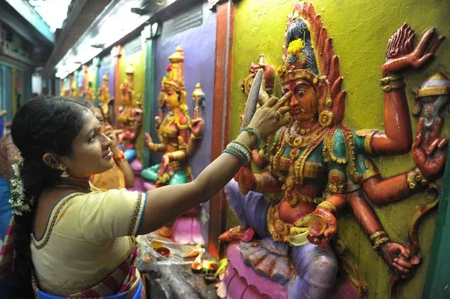 Indian Hindu woman offer prayers to the Hindu Goddess Lakshmi, also known as “Varalakshmi Vratham”, at a temple in Hyderabad on August 4, 2017. The Varalaxmi Vratam is celebrated by married women in order to invoke the blessings of Goddess Lakshmi for their husbands and family members. (Photo by Noah Seelam/AFP Photo)