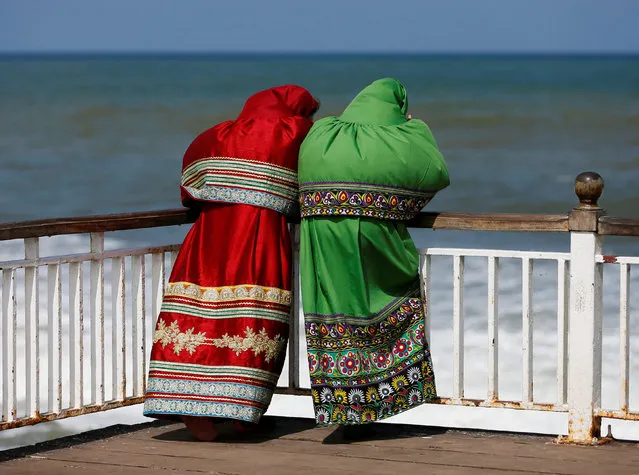 Two Muslim women talk on a seafront bridge during the holy fasting month of Ramadan in Colombo, Sri Lanka July 5, 2016. (Photo by Dinuka Liyanawatte/Reuters)