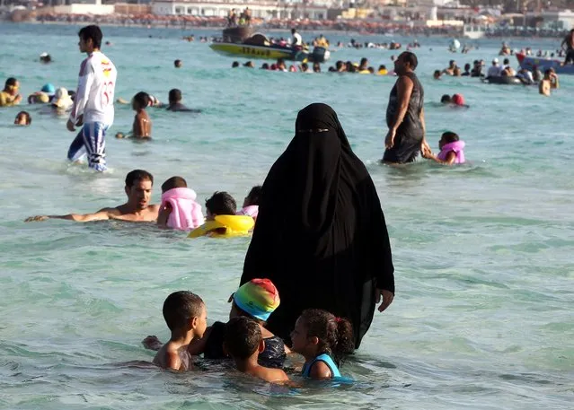 An Egyptian family spends time on the beach in Marca Matroh, Cairo, August 5, 2014. (Photo by Khaled Elfiqi/EPA)
