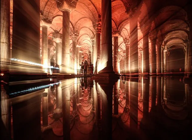 People are reflected in the waters of the Basilica Cistern while visiting the historic site in Istanbul, Turkey, 24 July 2022. (Photo by Sedat Suna/EPA/EFE)