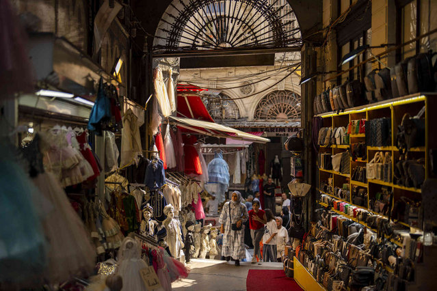 People walk along a commercial alley in a street market at Eminonu area in Istanbul, Turkey, Thursday, August 29, 2024. (Photo by Francisco Seco/AP Photo)