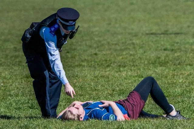 Police officers speak to a woman in Greenwich Park in London, England on April 4, 2020. The Government has announced a lockdown to slow the spread of Coronavirus and reduce pressure on the NHS. (Photo by Alamy Live News)