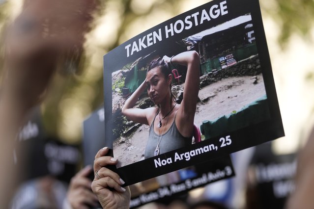 A woman holds a photo during the “Jewish Community Vigil” for Israel in London, Monday, October 9, 2023 two days after Hamas fighters launched an unprecedented, multi-front attack on Israel which killed more than 700 people. The militants blew through a fortified border fence and gunned down civilians and soldiers in Israeli communities along the Gaza frontier during a Jewish holiday. (Photo by Kin Cheung/AP Photo)